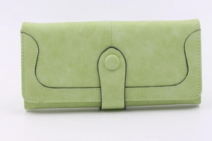 Detail of light green suede wallet with contrast stitching and round button closure