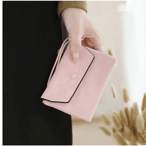 Pink leaf pendant clutch bag featuring envelope flap design and sleek wrist strap details