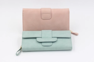 Detail of pink and mint green long wallets in frosted leather with heart pendants