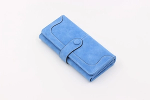 Detail of royal blue suede long wallet featuring snap closure and white stitching