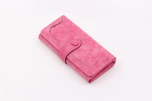 Detail view of rose pink long bifold wallet featuring matte suede texture and white stitching