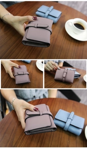Detail of short tri-fold leather wallet with litchi texture and decorative top stitching
