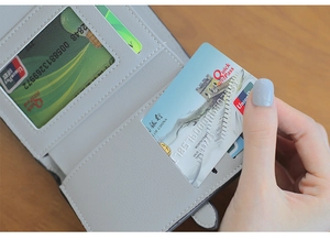 Close-up of light gray short wallet showing card slots and transparent ID window