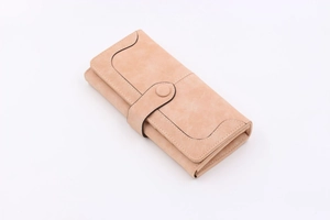 Detail view of wavy stitching on elegant nude long folding wallet with button closure