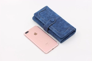 Long blue suede wallet with snap closure and white stitching shown with phone for size