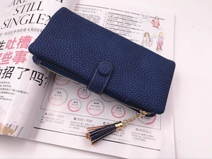 Dettaglio del portafoglio lungo blu scuro in pelle martellata con nappa decorativa