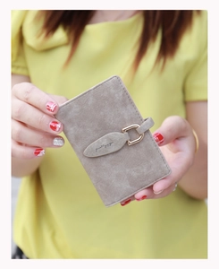 Detailed close-up of light brown matte leather wallet featuring a vintage leaf metal buckle