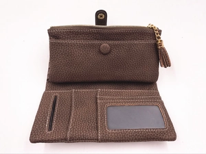 Dettaglio macro del portafoglio in pelle marrone con zip dorata e fessure per carte