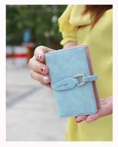 Detail of bifold wallet in blue and pink with leaf snap closure and metal ring