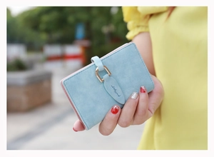 Close-up of light blue frosted wallet with gold horseshoe buckle and pink interior contrast