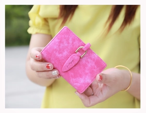 Detail of rose pink matte leather card holder with gold clasp and 'pretty' engraving