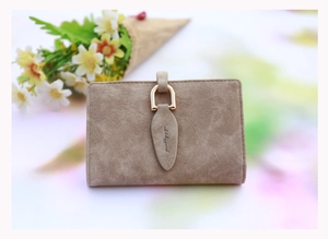 Macro detail of brown suede texture on women card wallet with leaf buckle