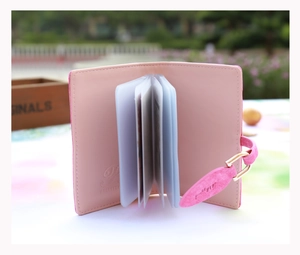 Pink matte card holder detail featuring organ-style clear slots and leaf charm