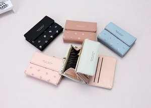 Detailed view of women's tri-fold floral wallet interior with card slots and metal clasp