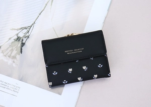 Detailed close-up of a floral black PU leather wallet with gold clasp and fine stitching