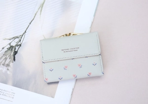 Detail shot of light green floral PU leather wallet with vintage gold metal clasp