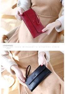 Detailed view of long leather wallets with wristlets in burgundy and black colors