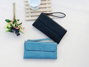 Close-up of stylish faux leather wallets with wrist straps in black and light blue colors
