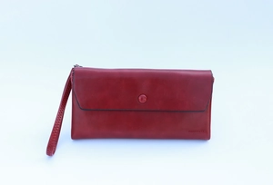 Detail of red envelope-style long wallet with brand embossing and adjustable wrist strap