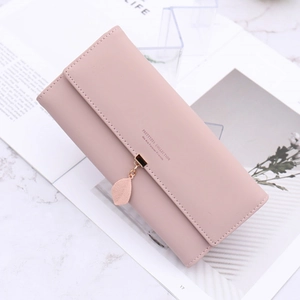 Pink long PU leather wallet for women with leaf pendant and snap closure on marble