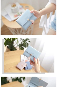Detail of light blue tri-fold PU leather wallet with a delicate metal leaf pendant clasp