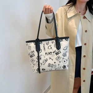 Chic off-white graffiti tote bag with black cartoon prints and thin shoulder straps