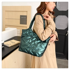 Gros plan du sac fourre-tout matelassé vert foncé avec finition métallique chic