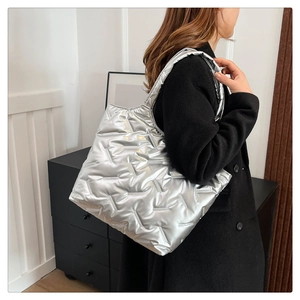 Borsa tote trapuntata argento portata a spalla in un moderno ambiente domestico