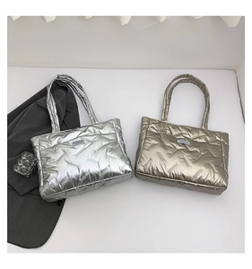 Close-up of quilted puffy tote bags in metallic silver and gold with fashion label