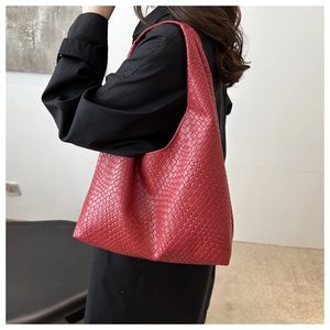 Dettaglio della borsa tote rossa in pelle intrecciata con texture intrecciato e design pulito