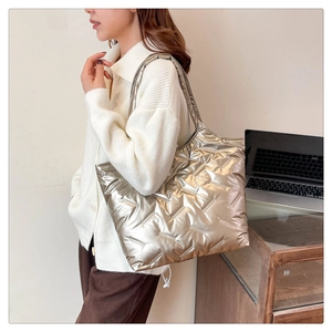 Détail d'un sac cabas matelassé champagne métallisé avec bandoulière large rembourrée