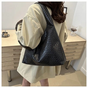 Sac fourre-tout tissé noir classique pour femmes, style porté épaule sur mannequin