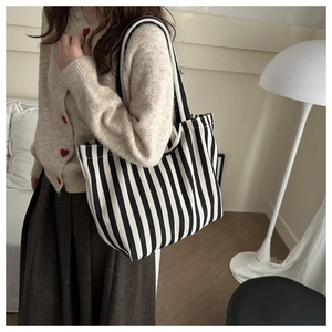 Minimalist black and white striped canvas tote bag styled with casual knitwear outfits
