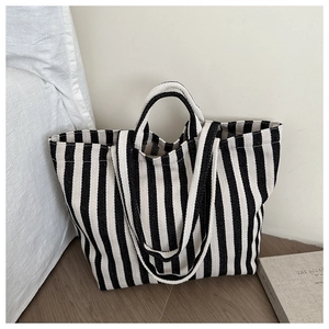Detail of black and white striped canvas tote bag showing dual straps and woven texture