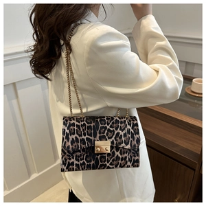 Detailansicht der Umhängetasche mit Leopardenmuster und goldener Kette am Modell