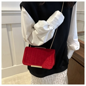 Red velvet quilted chain strap shoulder bag shown on model with elegant outfits