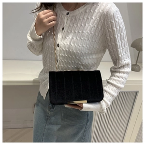 Elegant black velvet crossbody bag with vertical quilting and golden chain strap