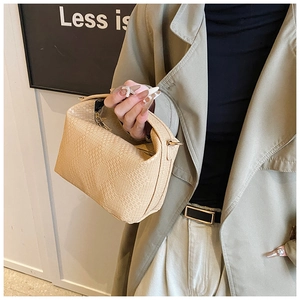 Detail der minimalistischen beigen Kissen-Tasche mit Goldbeschlägen und Textur