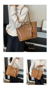 Detail view of brown leather tote bag with teddy bear charm and striped strap
