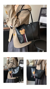 Detail of black tote bag with plush bear charm and ribbon on a minimalist background