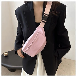Detailed view of a light pink nylon crossbody waist bag with silver metal zipper and strap buckle