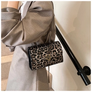 Detail of leopard print crossbody bag with gold square studs and metallic turn-lock