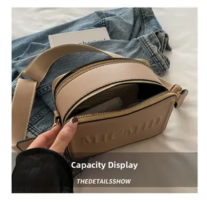 Detail view of beige crossbody bag interior space showing capacity for mobile and wallet