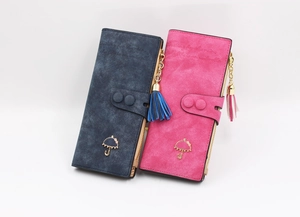 Detail view of long tassel wallets in dark blue and rose red with metal umbrella charm