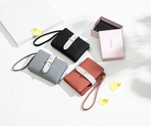 Detailed view of floral stripe and gold bow buckle on compact PU leather wallets