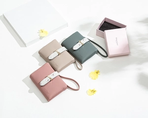 Detailed view of pebbled leather wallets in pink, beige, and green with golden bows