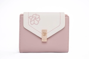 Close-up of pink floral embroidery and rose gold metal clasp on a folded wallet