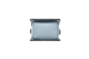 Detail view of light blue lychee-textured leather crossbody bag with gold metal D-ring