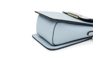 Detail of light blue lychee pattern leather with black oil edges and gold metal buckle