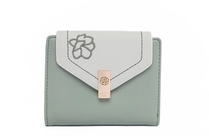 Detail of flower embroidery and rose gold metal clasp on a tri-fold leather wallet